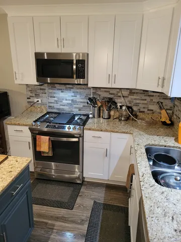 a bathroom with a granite countertop sink a mirror and shower