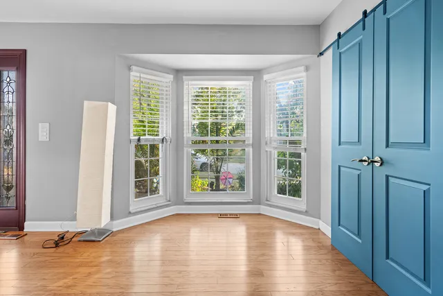 a view of a hallway with wooden floor and a livingroom
