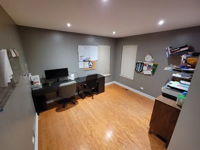 a bedroom with a bed a mirror on dresser and a window