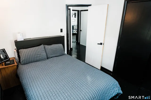 a bedroom with a bed and wooden floor