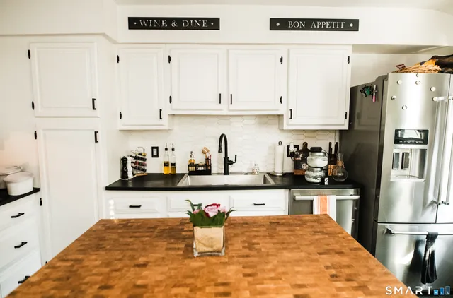 a kitchen with stainless steel appliances granite countertop a refrigerator and a stove top oven