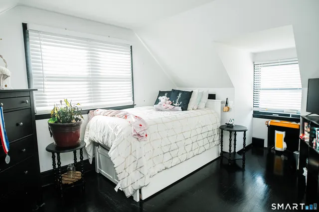 a bedroom with a bed and a table chair