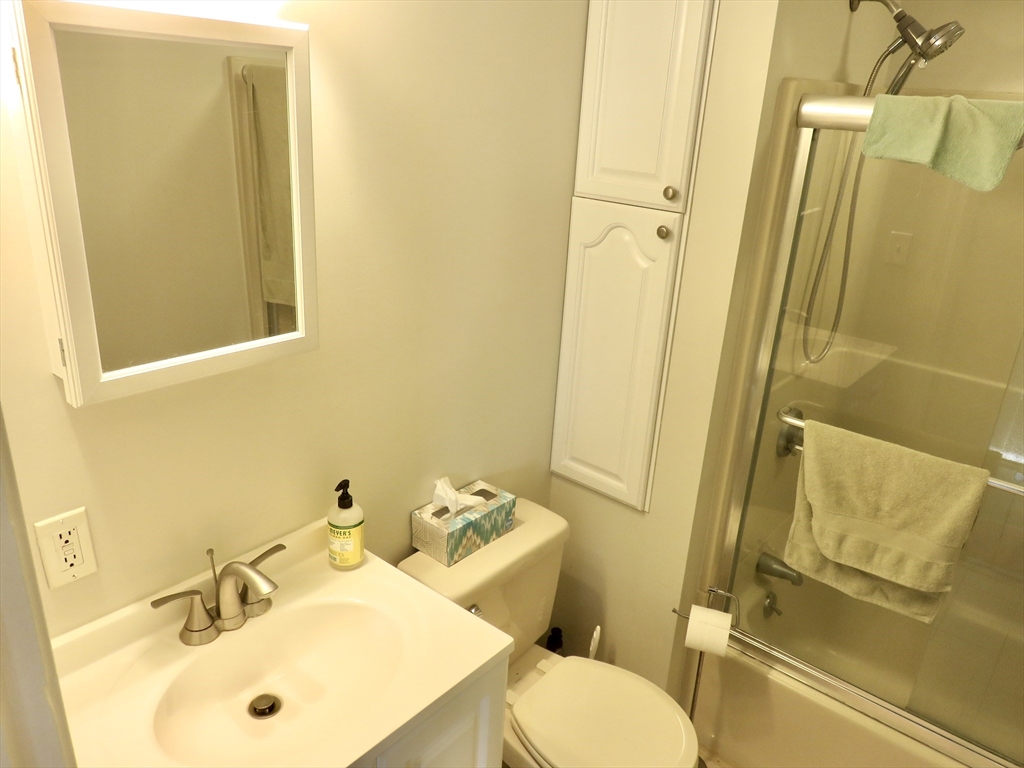 105 Plympton Street, Unit 2 Waltham, MA 02451 - Photo 23 of 27 a bathroom with a sink and mirror with toilet