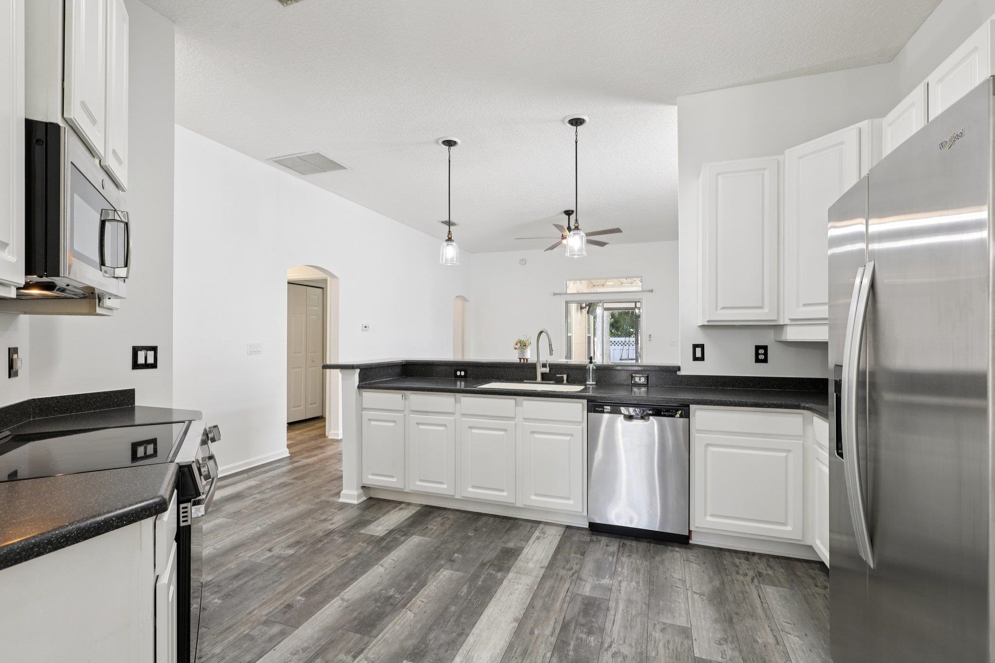 1821 Keswick Road St. Augustine, FL 32084 - Photo 14 of 57 a kitchen with stainless steel appliances a sink a stove a refrigerator and cabinets