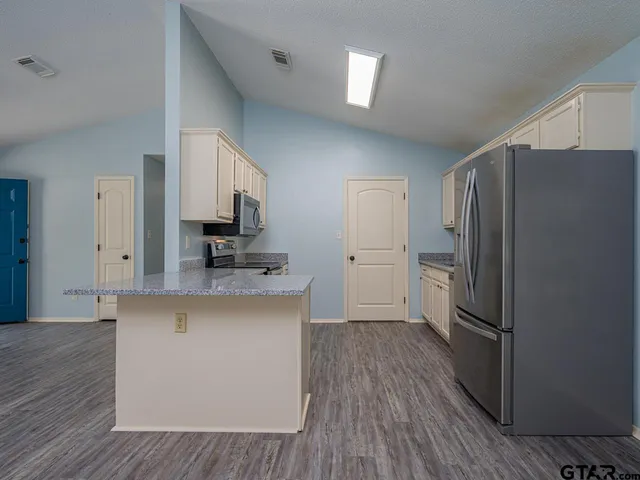 a kitchen with stainless steel appliances a refrigerator and a stove top oven