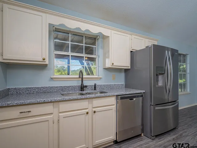 a kitchen with appliances a sink and a window