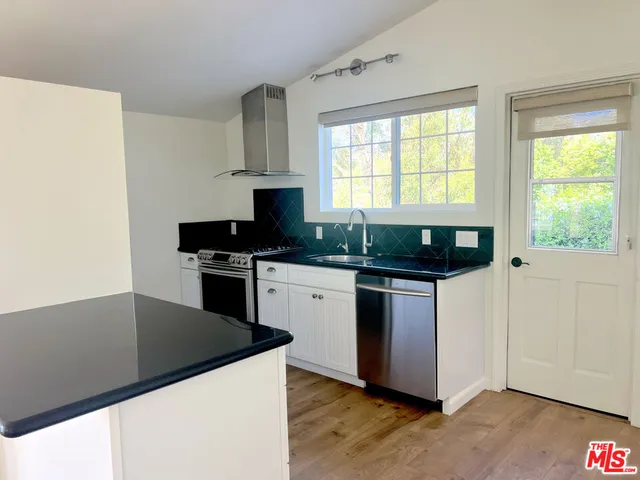 a kitchen with granite countertop a stove and a microwave