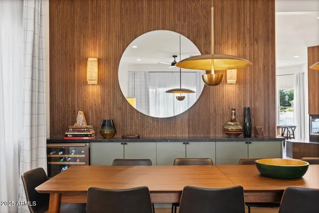 a bedroom with a bed lamp and a large mirror on the dresser