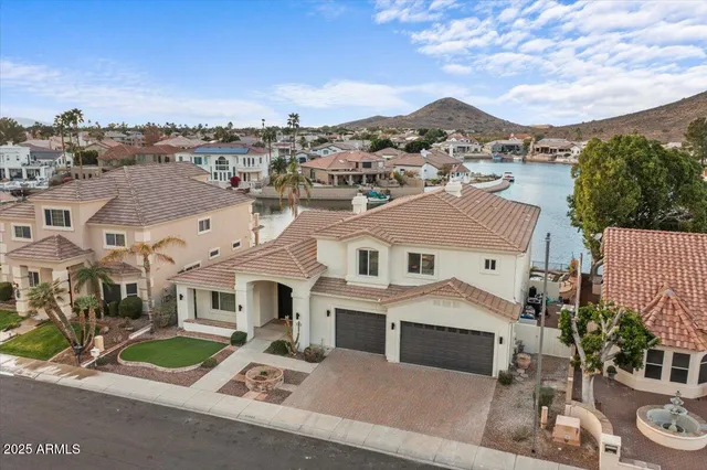 a front view of a house with a yard and mountain view in back