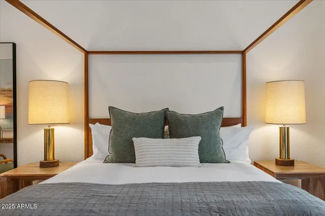 a bedroom with a bed and a flat tv screen on the dresser