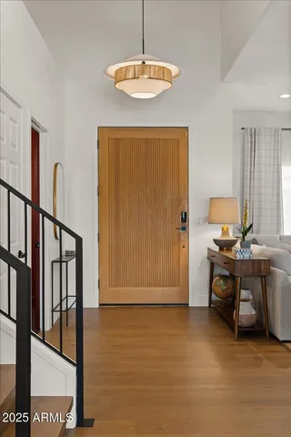 a living room with stainless steel appliances kitchen island granite countertop a stove a sink a dining table and chairs with wooden floor