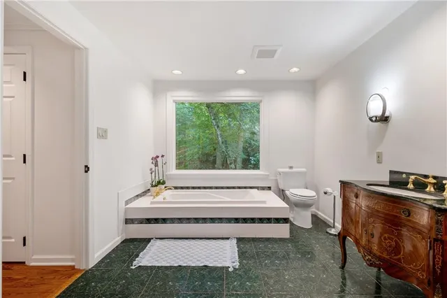 an empty room with wooden floor cabinet and windows