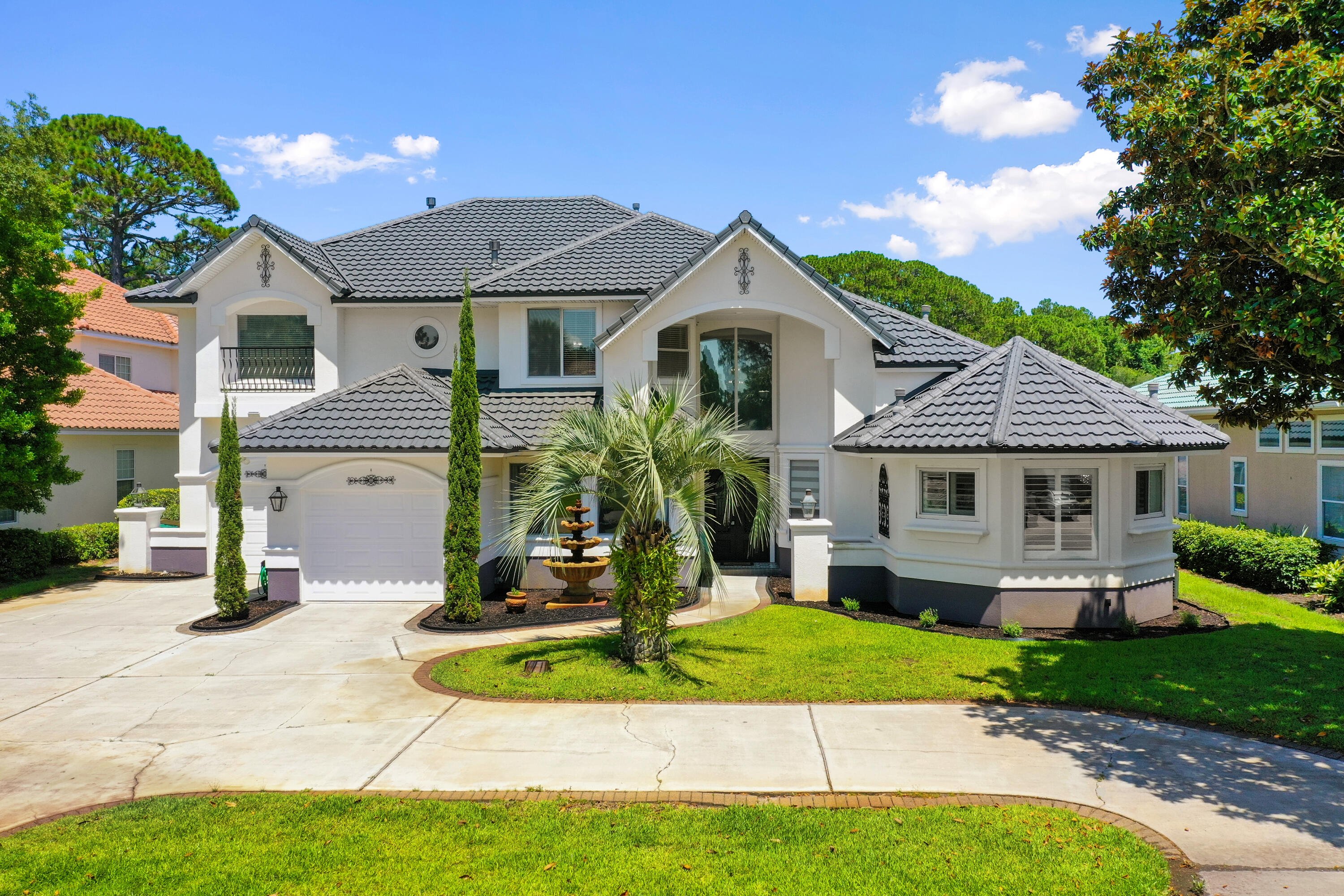 a front view of a house with a yard and potted plants