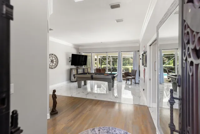 a living room with a flat screen tv and a floor to ceiling window