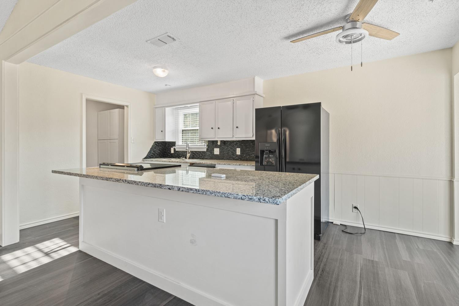 6154 38th Street Lubbock, TX 79407 - Photo 11 of 23 a kitchen with granite countertop a sink and a refrigerator