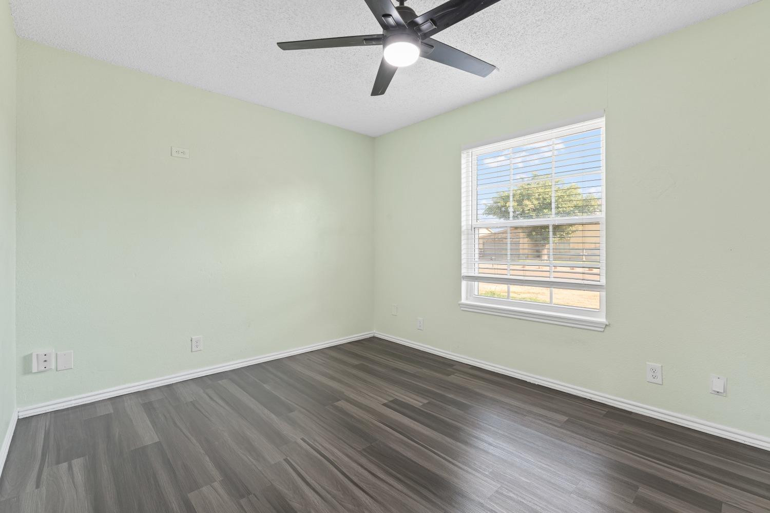 6154 38th Street Lubbock, TX 79407 - Photo 16 of 23 a view of an empty room with wooden floor and a window