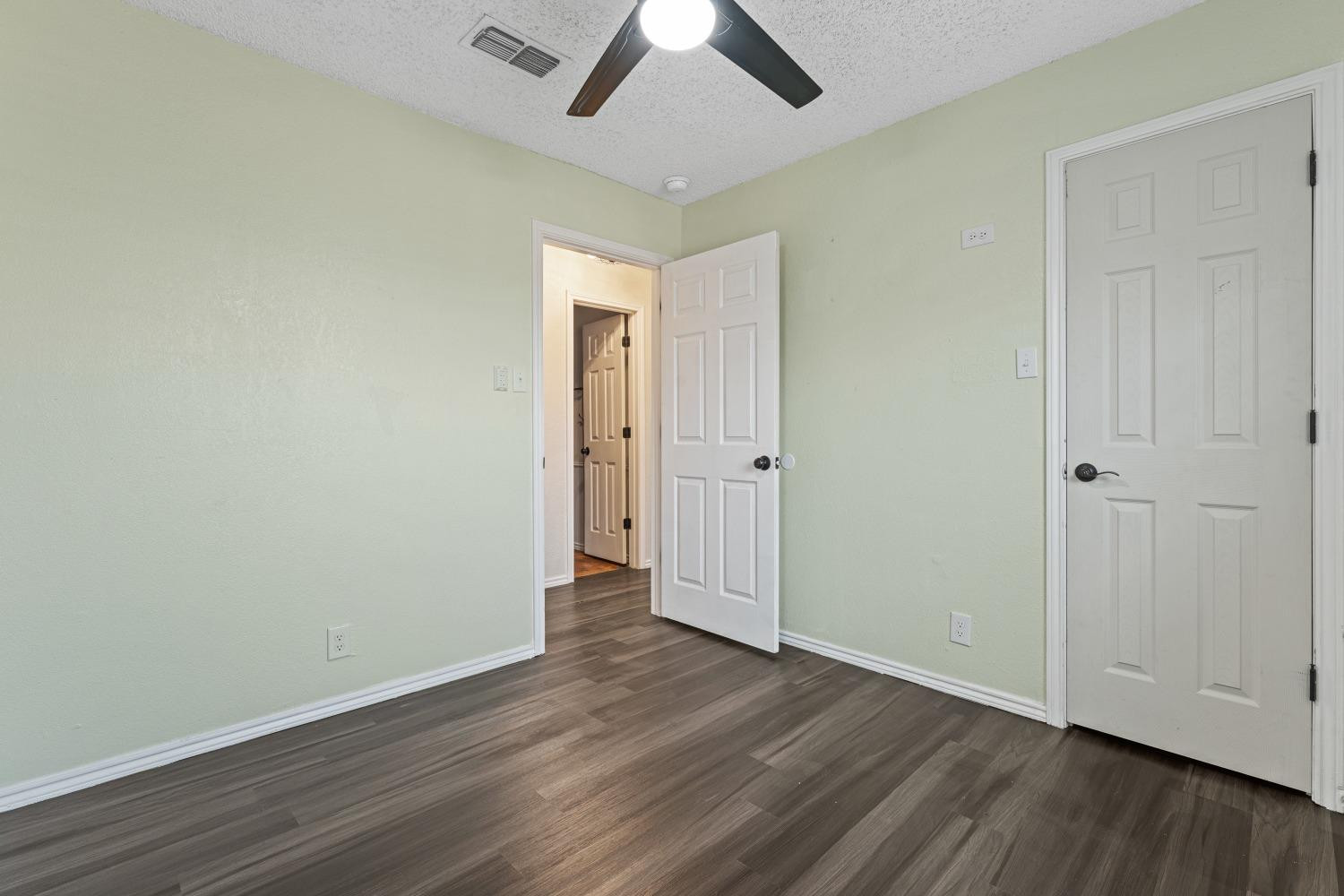 6154 38th Street Lubbock, TX 79407 - Photo 20 of 23 an empty room with wooden floor a ceiling fan and closet