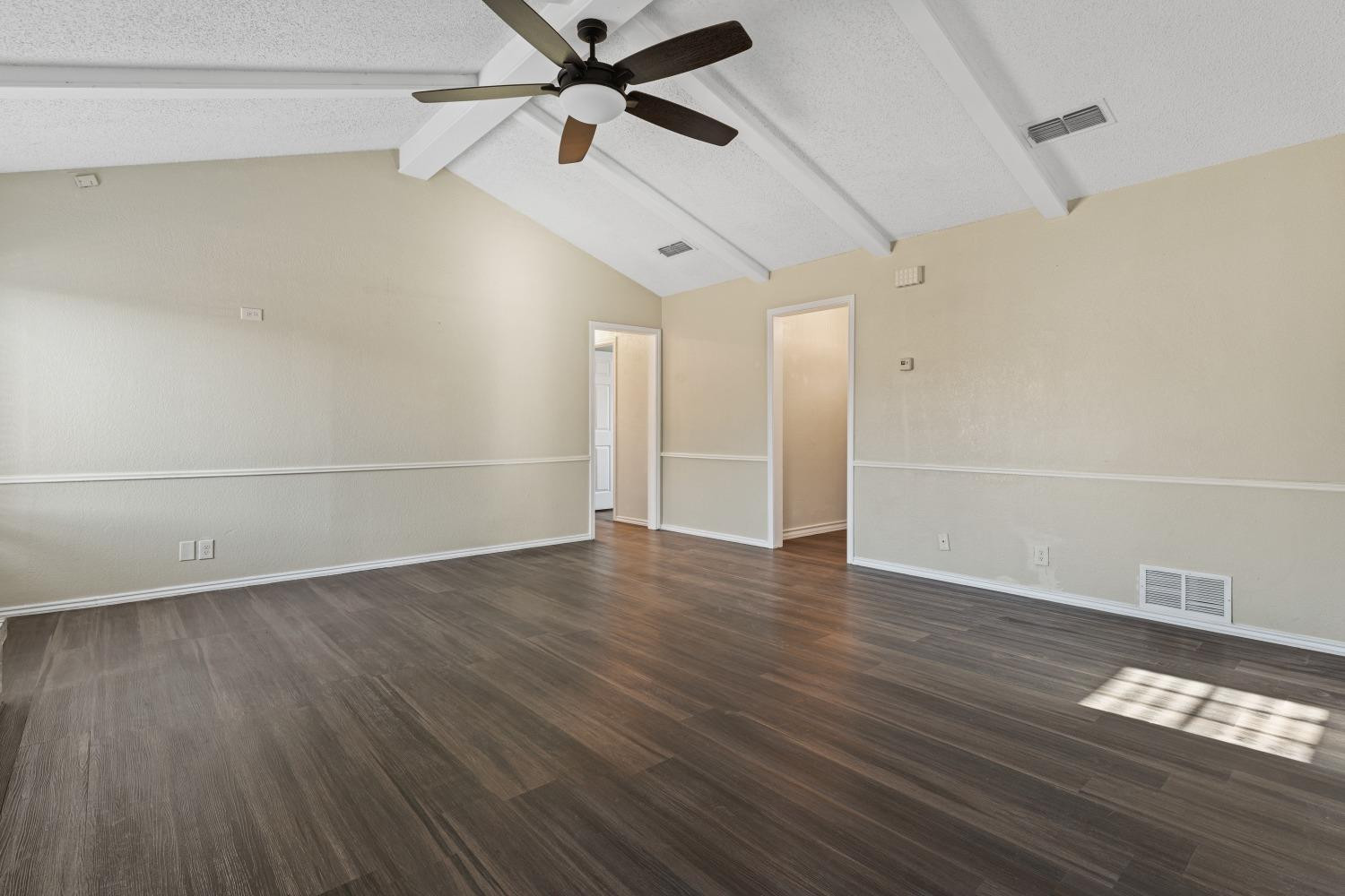 6154 38th Street Lubbock, TX 79407 - Photo 8 of 23 an empty room with wooden floor fan and windows