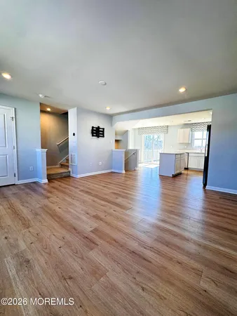 a kitchen with stainless steel appliances granite countertop a stove top oven a refrigerator and a granite counter tops with wooden floors