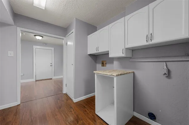 a view of a storage and utility room with wooden floor