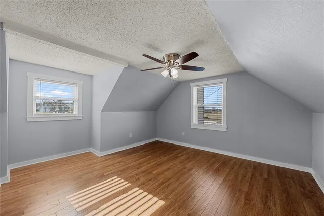 a view of an empty room with a window and a ceiling fan