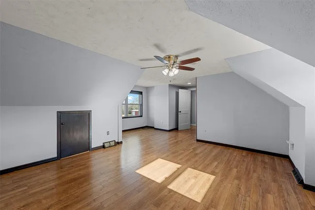 a view of a livingroom with wooden floor and ceiling fan