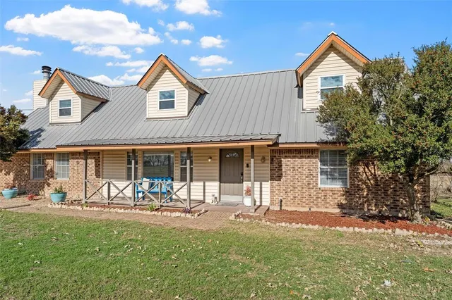 a front view of a house with a yard and a garden