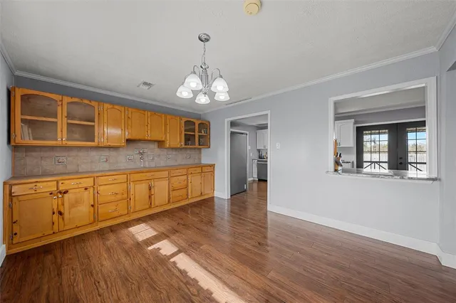 a large kitchen with stainless steel appliances granite countertop a oven a stove and a wooden floors