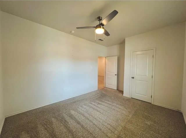 a view of an empty room and a ceiling fan