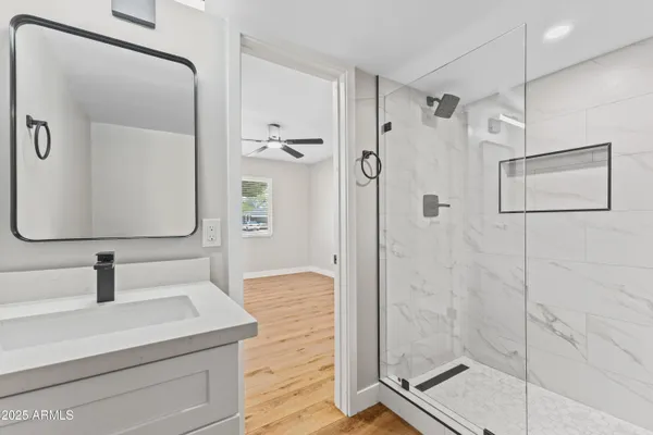 a bathroom with a shower sink and mirror