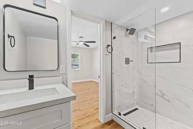 a bathroom with a shower sink and mirror
