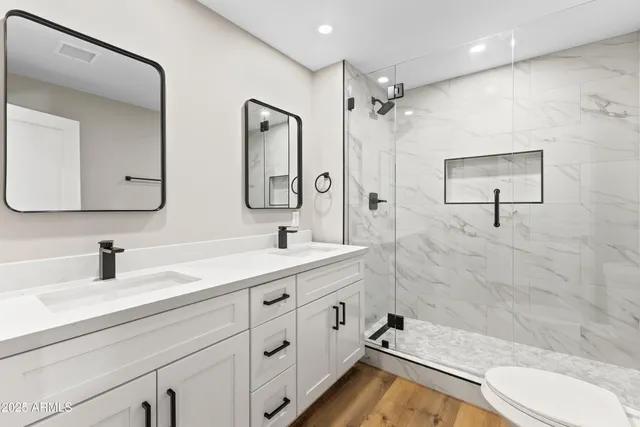 a bathroom with a double vanity sink mirror double and shower