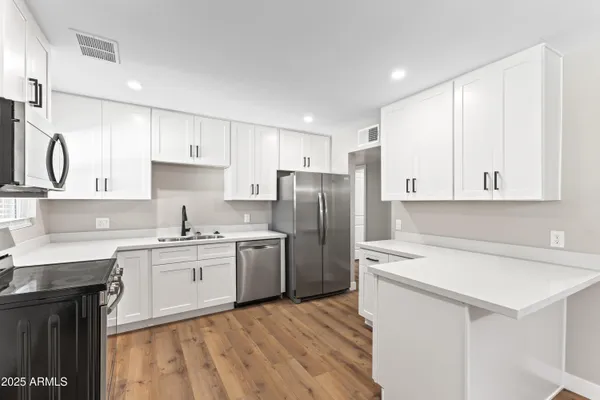 a kitchen with stainless steel appliances granite countertop a sink stove and refrigerator