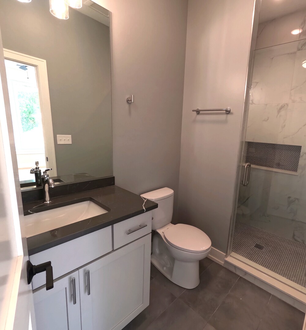2100 West 18th Place, Unit 401 Chicago, IL 60608 - Photo 12 of 13 a bathroom with a granite countertop sink mirror vanity and toilet