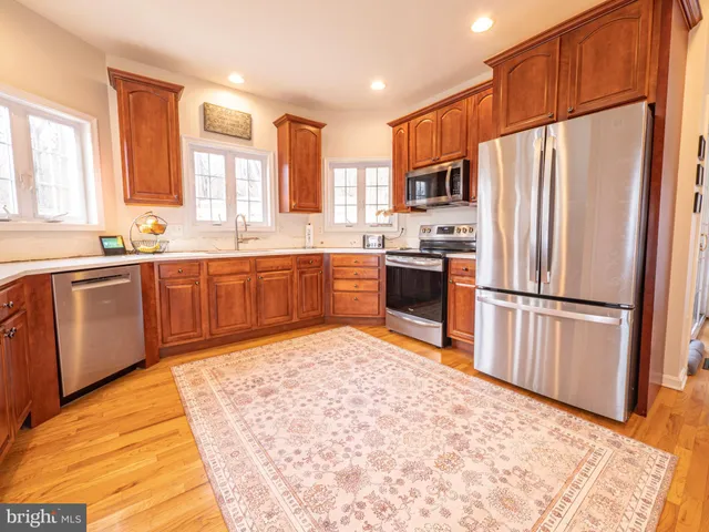 a large kitchen with stainless steel appliances granite countertop a stove and a sink