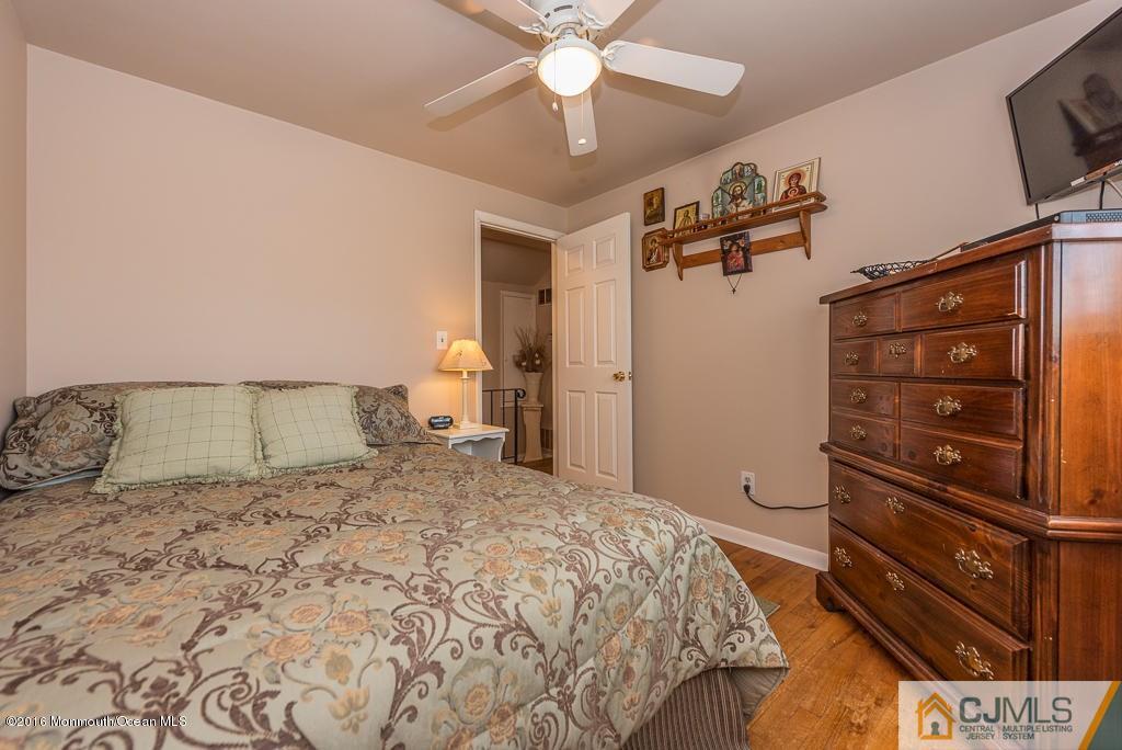 130 Bethany Road Hazlet, NJ 07730 - Photo 17 of 24 a bedroom with a bed and a chandelier