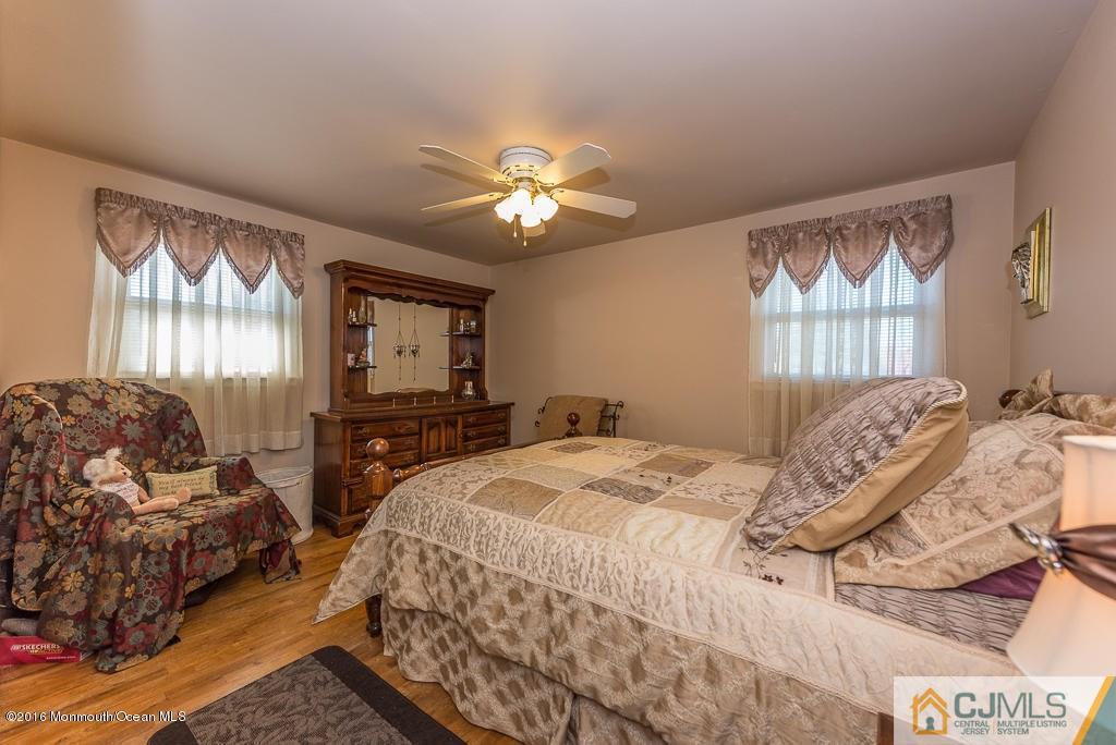 130 Bethany Road Hazlet, NJ 07730 - Photo 18 of 24 a spacious bedroom with a bed and a chandelier