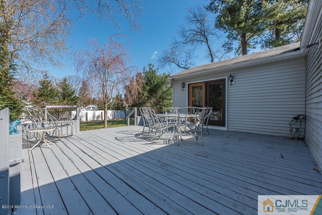 130 Bethany Road Hazlet, NJ 07730 - Photo 21 of 24 a view of a roof deck with table and chairs a barbeque with wooden floor and fence