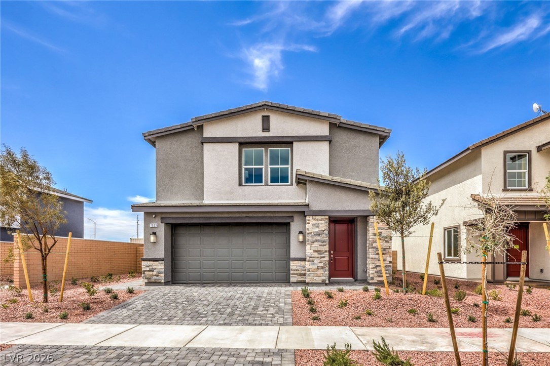 1013 Copper Robin Street Henderson, NV 89011 - Photo 1 of 43 Photo is representational only; actual home finishes may vary. Traditional-style home with an attached garage, stucco siding, decorative driveway, and stone siding