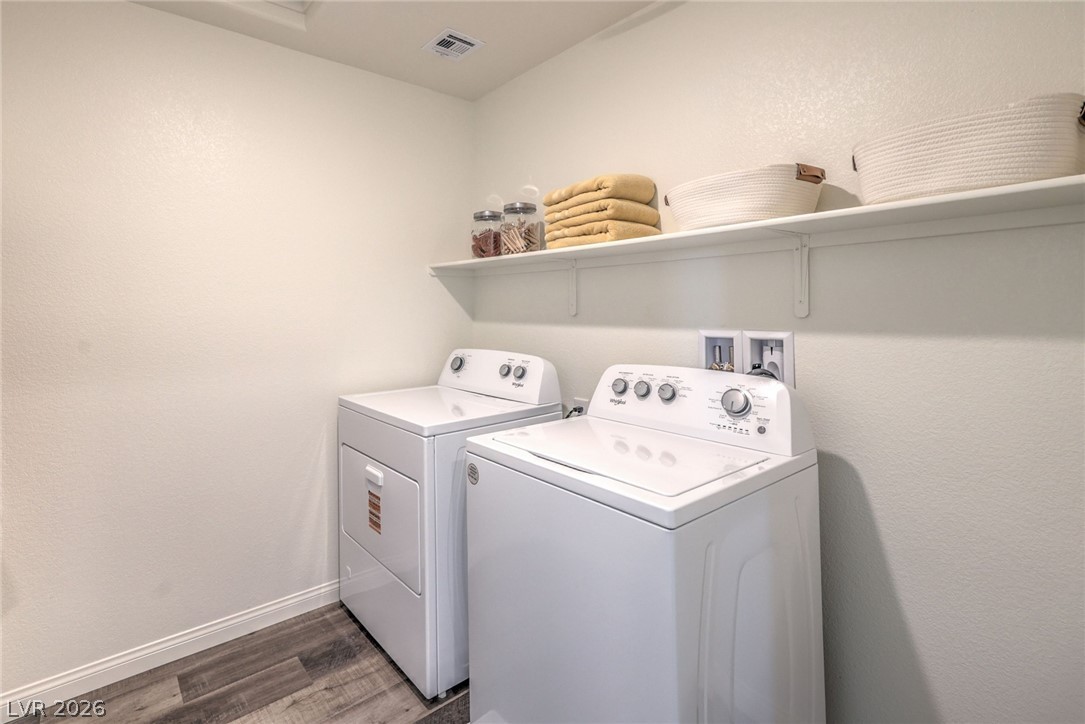 1013 Copper Robin Street Henderson, NV 89011 - Photo 37 of 43 Washer and Dryer are not included. Photo is representational only; actual home finishes may vary. Laundry room featuring washer and dryer, wood finished floors, and baseboards
