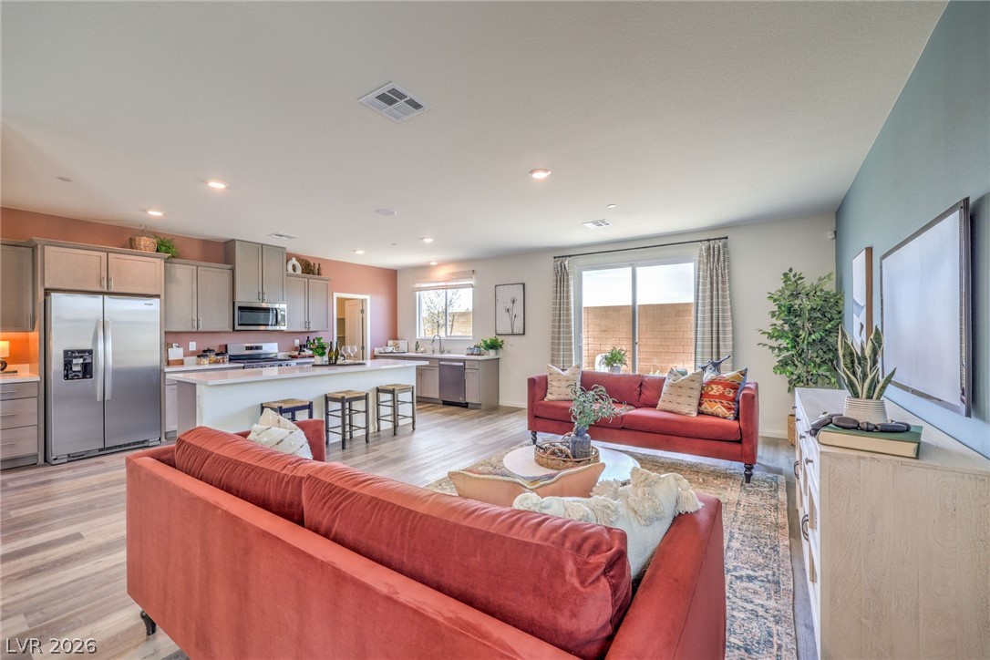 1013 Copper Robin Street Henderson, NV 89011 - Photo 9 of 43 Living room with light wood-type flooring and recessed lighting. Photo is representational only; actual home finishes may vary.