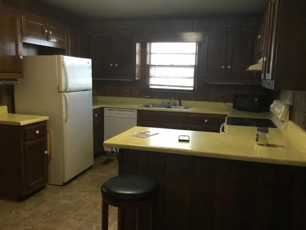 a kitchen with a sink a refrigerator and cabinets