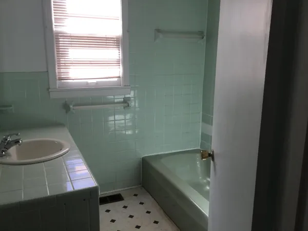 a bathroom with a sink toilet and window