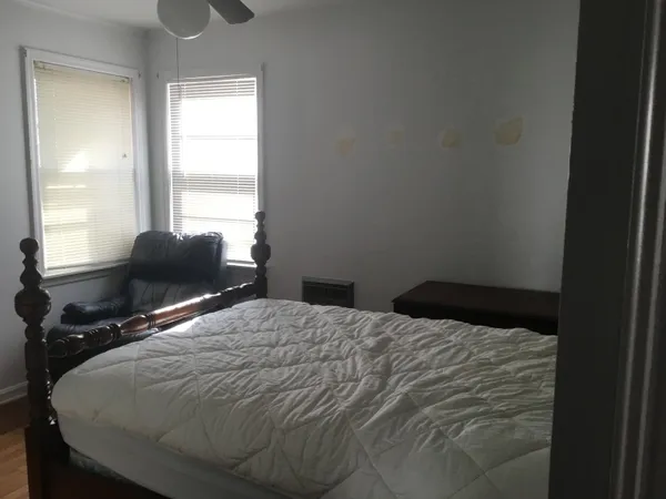 a bedroom with a bed and windows