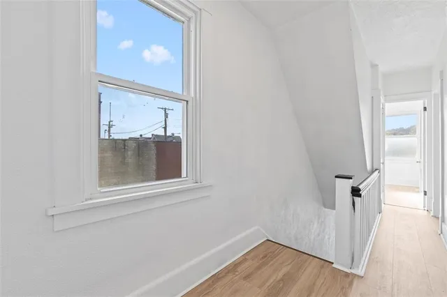 a view of a small space with wooden floor and a window