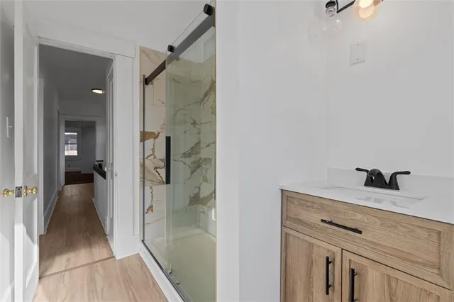 a bathroom with a granite countertop sink a mirror and shower