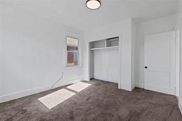 an empty room with windows and closet