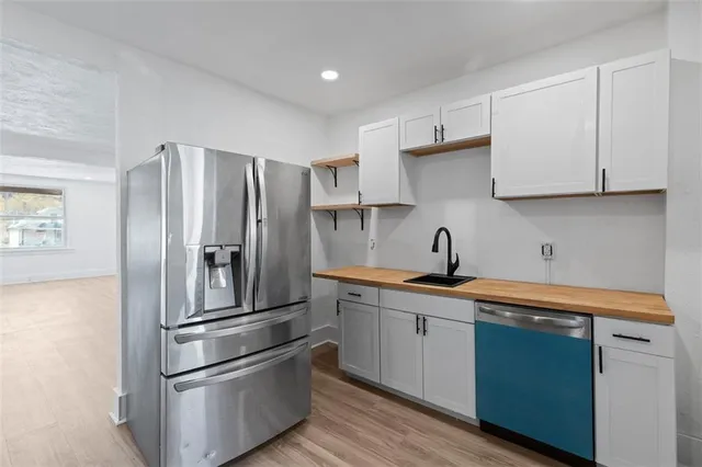 a kitchen with stainless steel appliances a refrigerator sink and cabinets