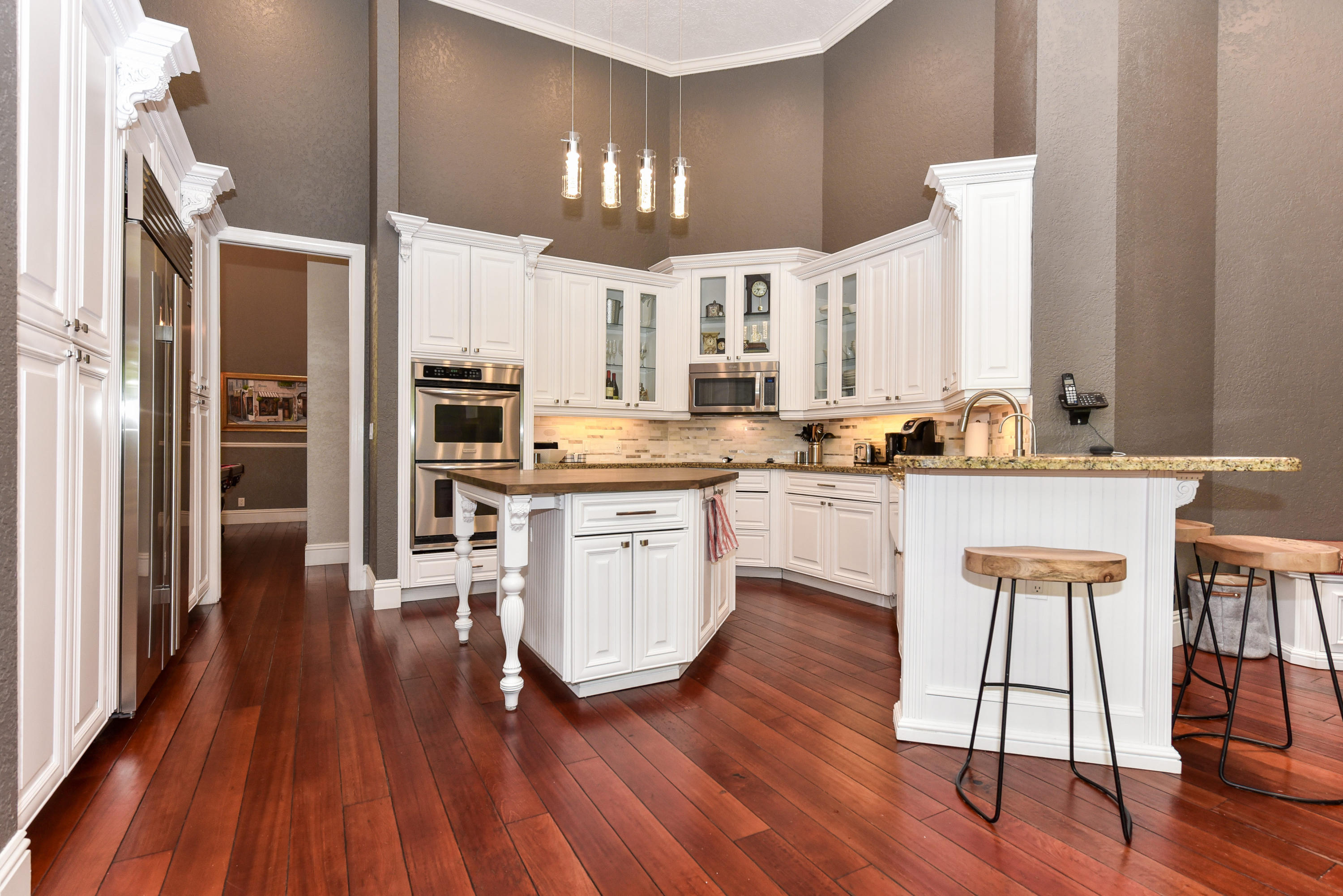 5855 Paddington Way Boca Raton, FL 33496 - Photo 14 of 40 a kitchen with wooden floors and white cabinets