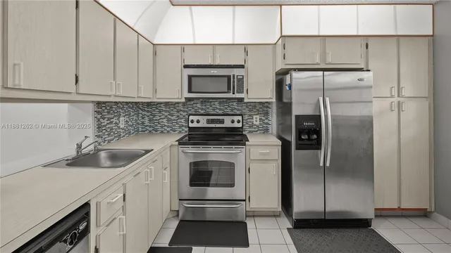 a kitchen with a refrigerator sink and cabinets
